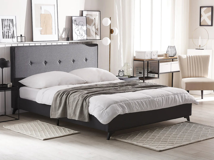 Modern bedroom with a gray upholstered bed, white bedding, and a desk.