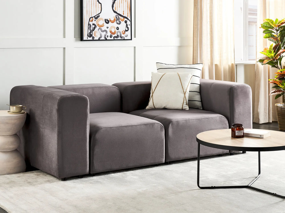 Gray sectional sofa in a living room with a coffee table and decorative items.