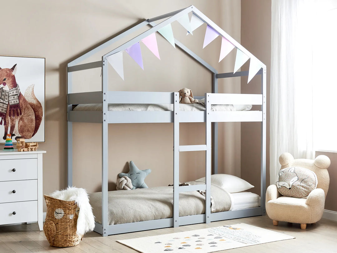 Children's room with a house-shaped bunk bed, chair, and decor.