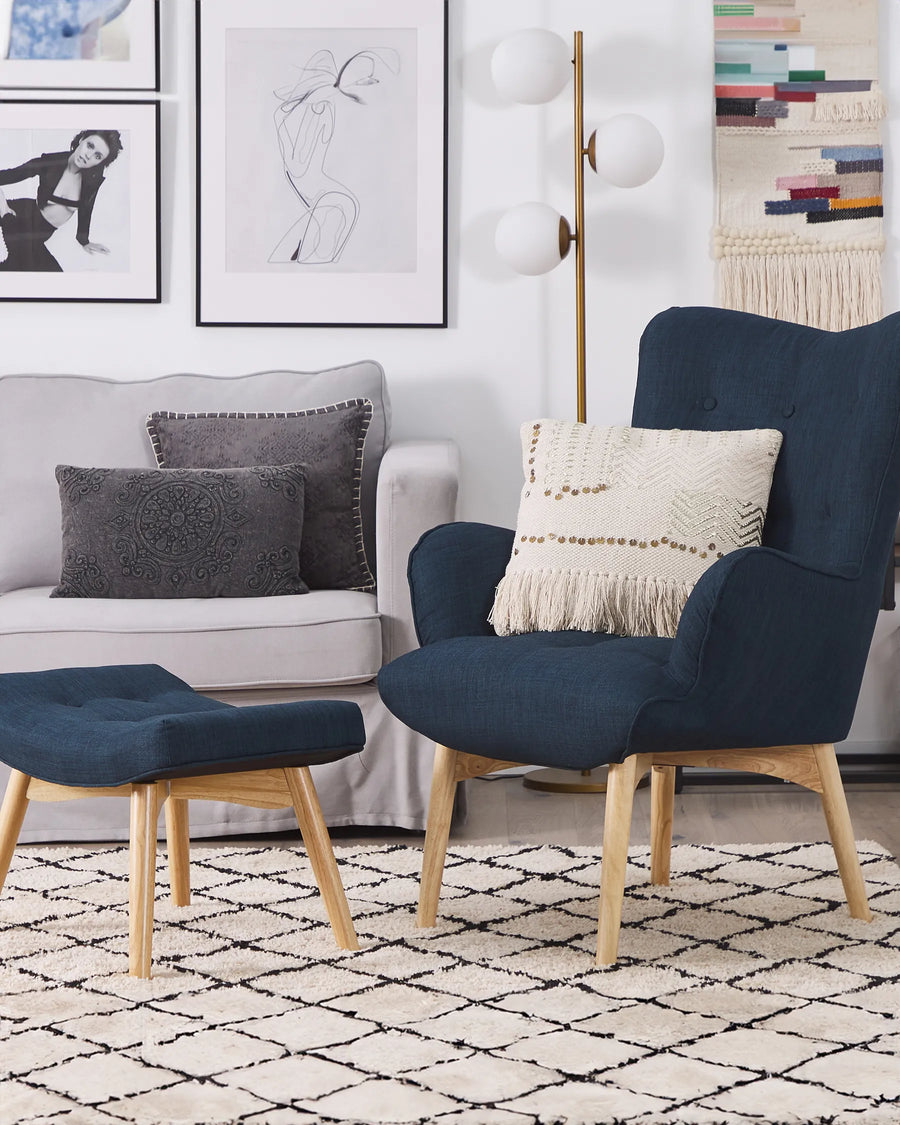 Modern living room with a navy armchair, ottoman, and gray sofa.