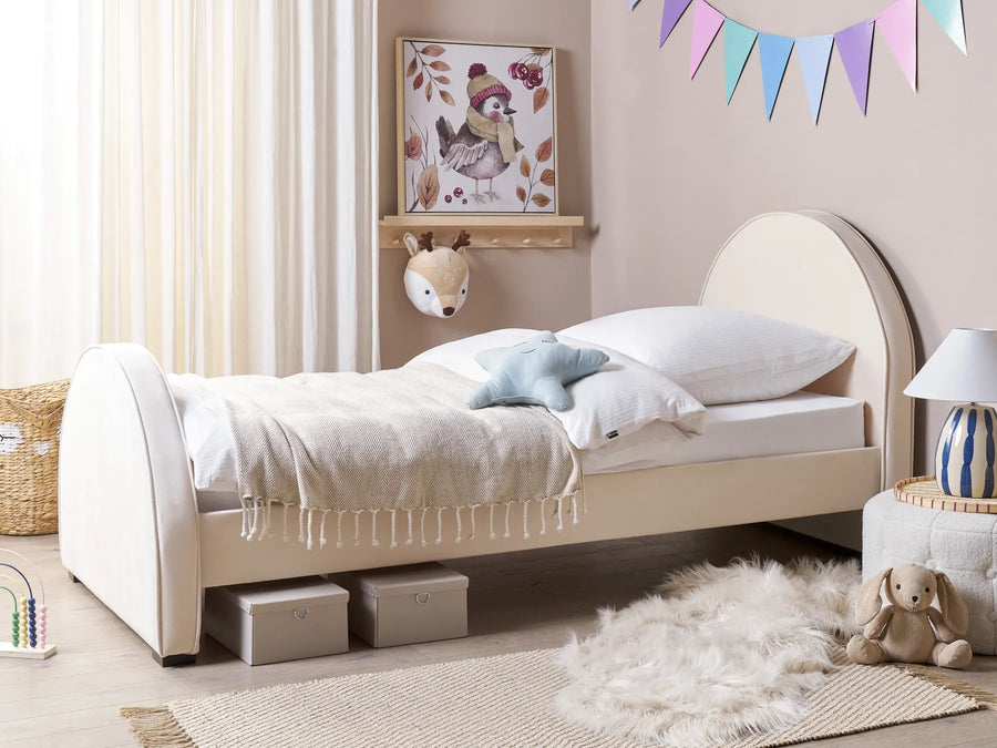 Children's bedroom with a beige bed, toys, and decorative elements.