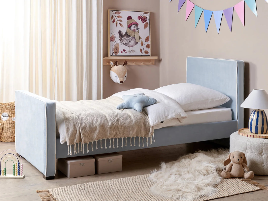 Children's bedroom with a gray bed, toys, and decorative elements.