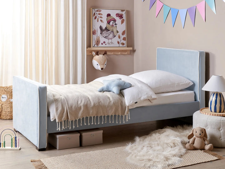 Children's bedroom with a gray bed, toys, and decorative elements.