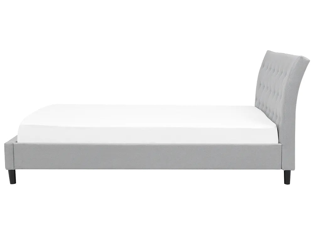 Gray upholstered bed with white mattress on a white background