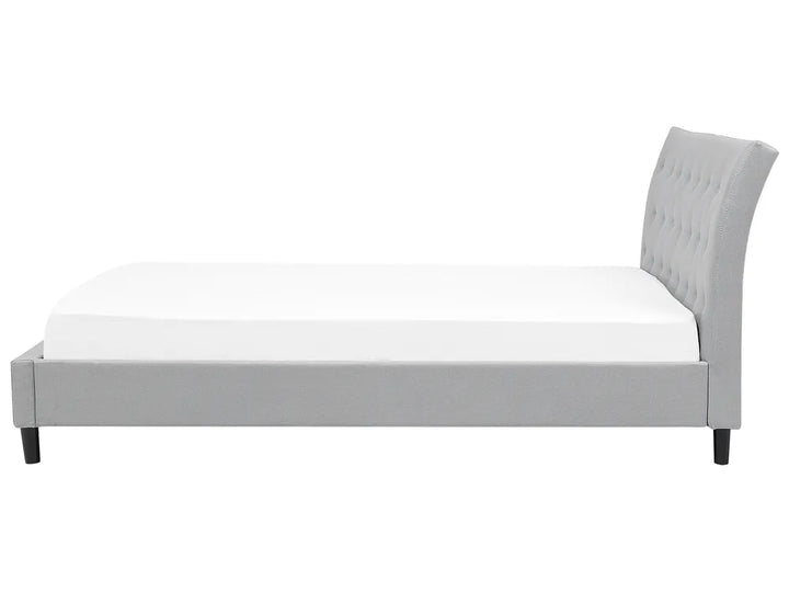 Gray upholstered bed with white mattress on a white background