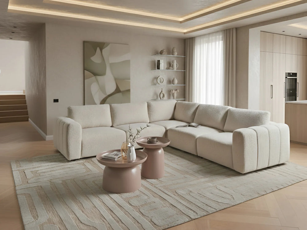 Modern living room with a beige sectional sofa, coffee tables, and abstract art on the wall.