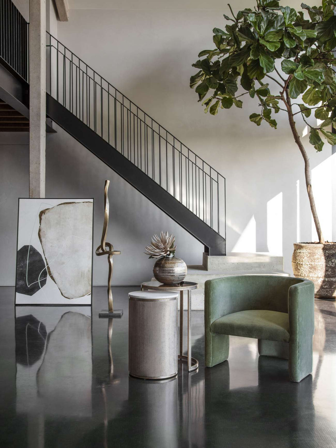 Modern interior with a staircase, green armchair, and decorative elements.