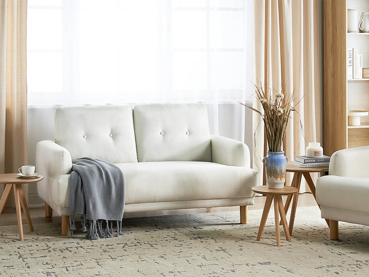 Modern living room with a white sofa, side tables, and decorative items.