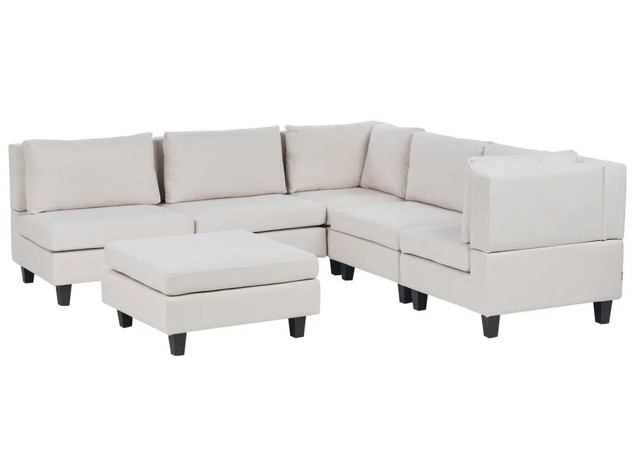 Beige sectional sofa with ottoman on a white background