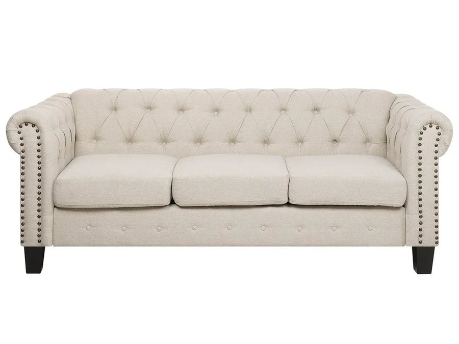 Beige tufted sofa with nailhead trim on a white background