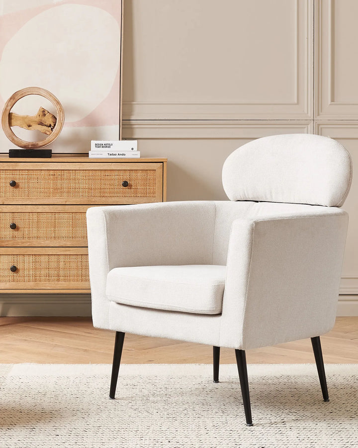 Upholstered in soft, neutral off-white fabric, this armchair complements both modern and traditional interiors effortlessly.