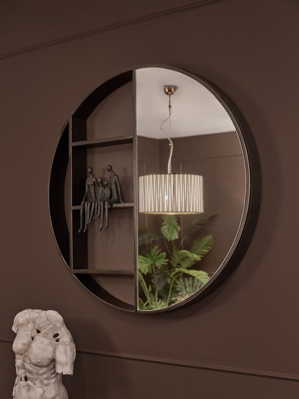 Round mirror on a brown wall with decorative elements