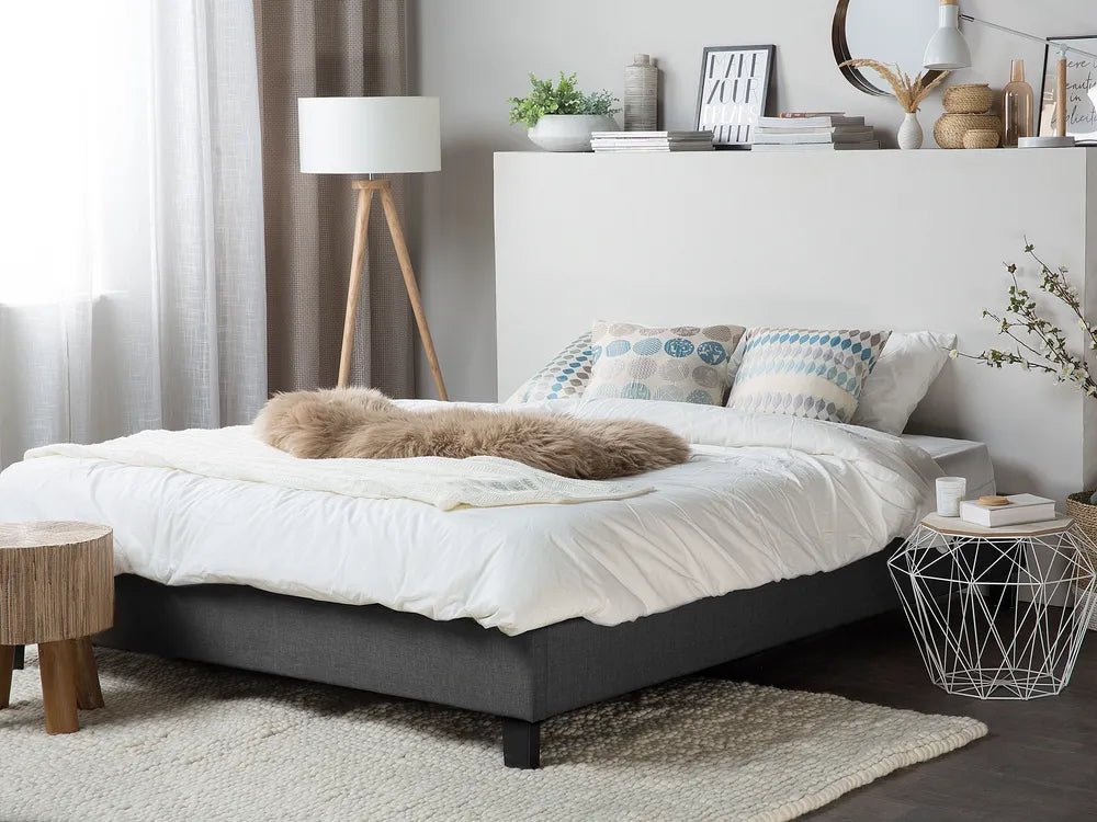 Modern bedroom with a bed, side tables, and decorative items.