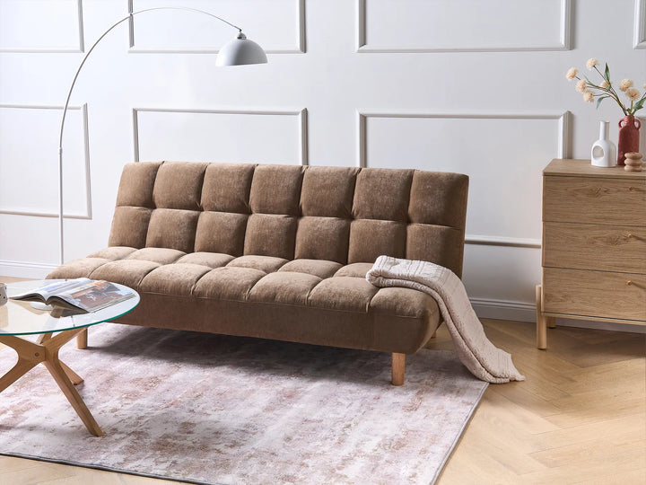 Brown sofa bed in a living room setting with a wooden cabinet and decorative items.