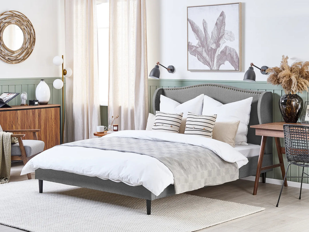 grey upholstered bed with curved headboard