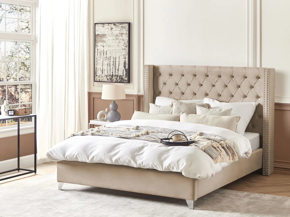 Beige upholstered bed with white bedding in a bright bedroom