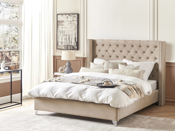 Beige upholstered bed with white bedding in a bright bedroom