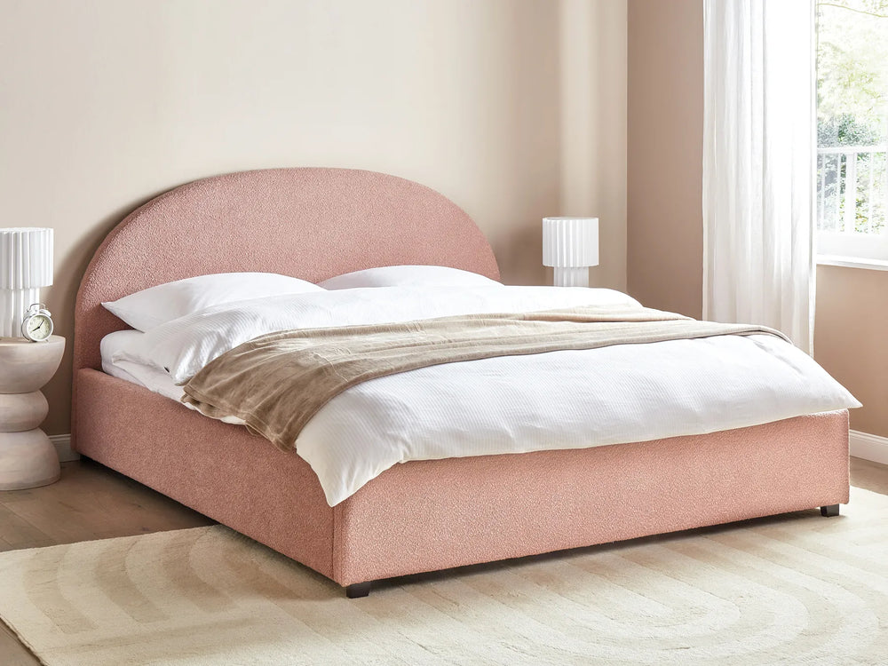 Pink upholstered bed with white bedding in a bedroom setting