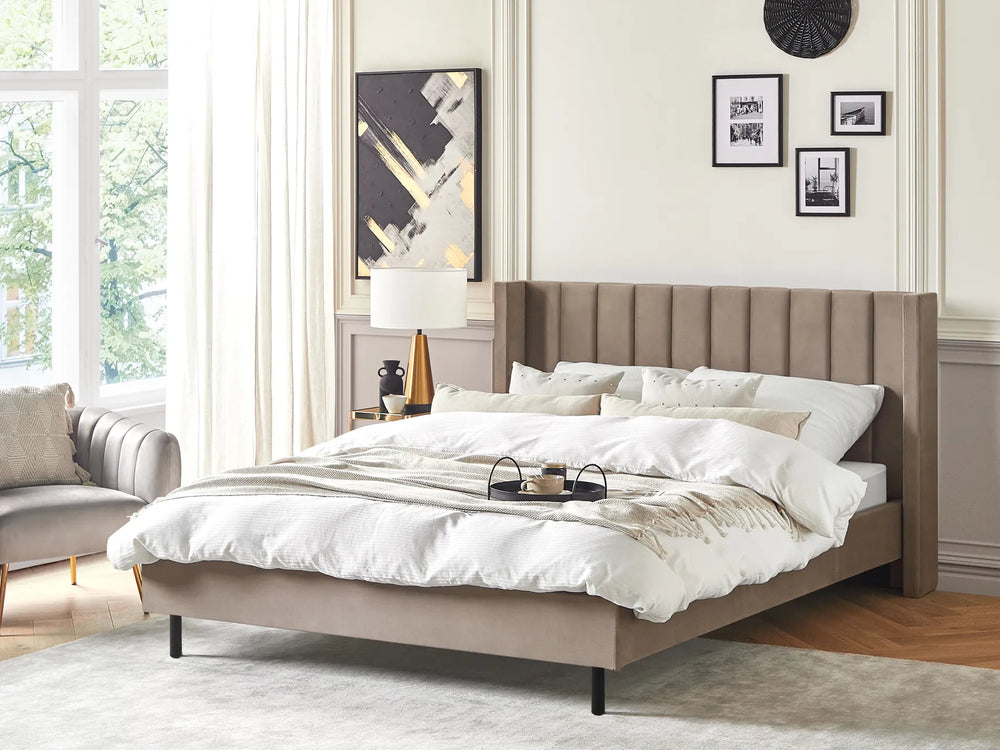 Beige upholstered bed in a modern bedroom with white bedding and decor.