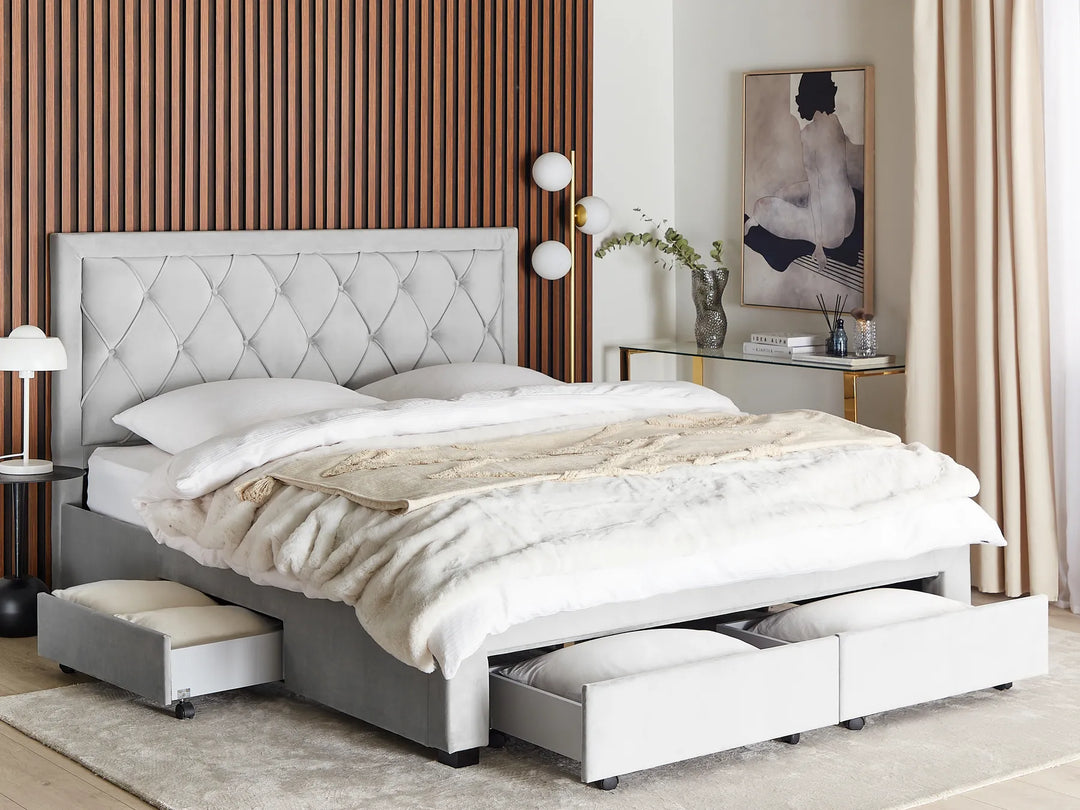 Gray upholstered bed with storage drawers in a bedroom setting.