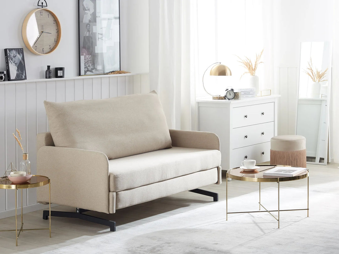 Beige sofa in a modern living room with white walls and decorative items.