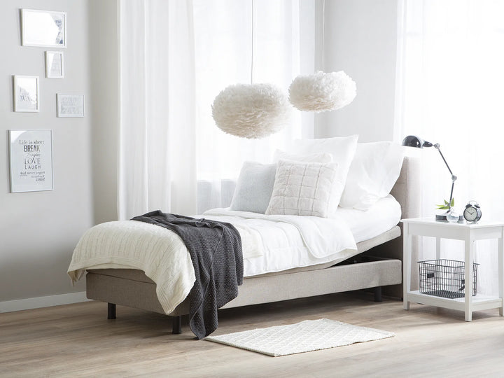 Modern bedroom with a bed, nightstand, and decorative elements.
