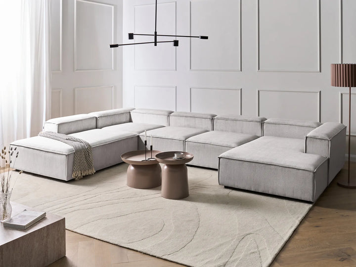 Modern living room with a gray sectional sofa, coffee table, and decorative elements.