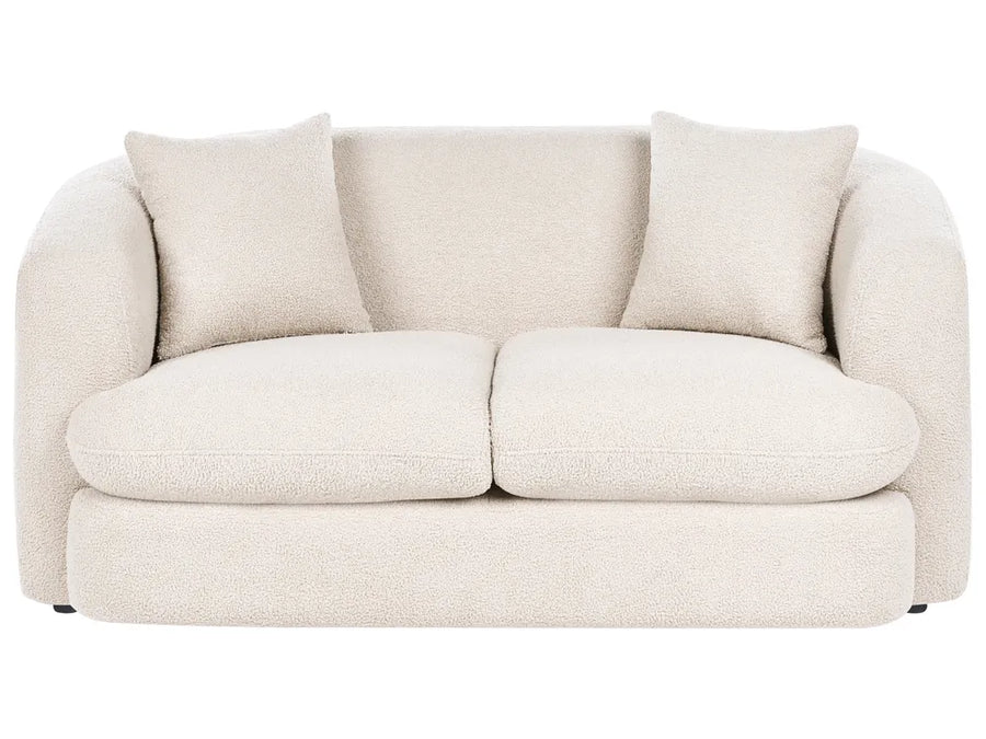 Beige sofa with two cushions on a white background