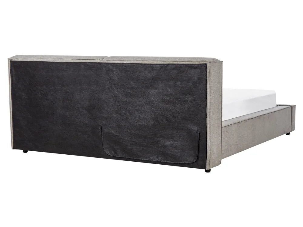 Bed with a dark upholstered headboard on a white background