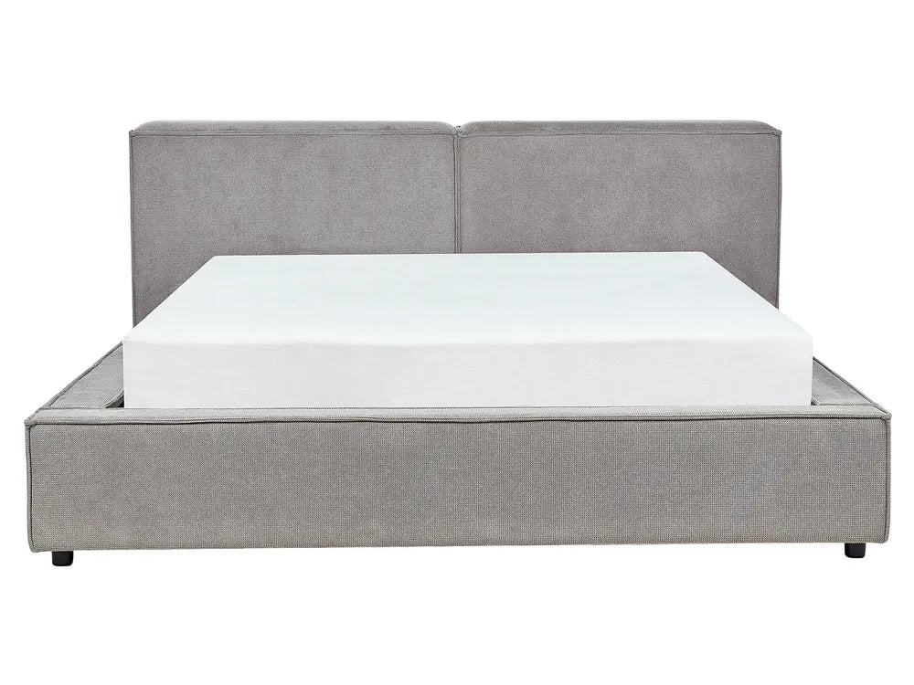 Gray upholstered bed with a white mattress on a white background