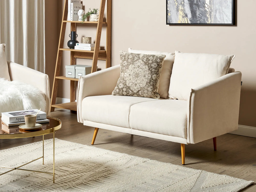 Beige sofa in a living room with a coffee table and decorative items.