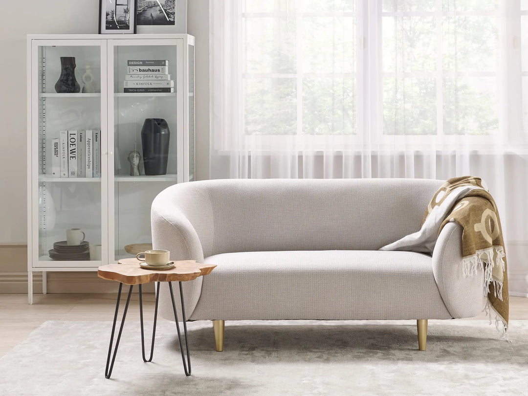 Modern living room with a gray sofa, wooden side table, and glass cabinet.