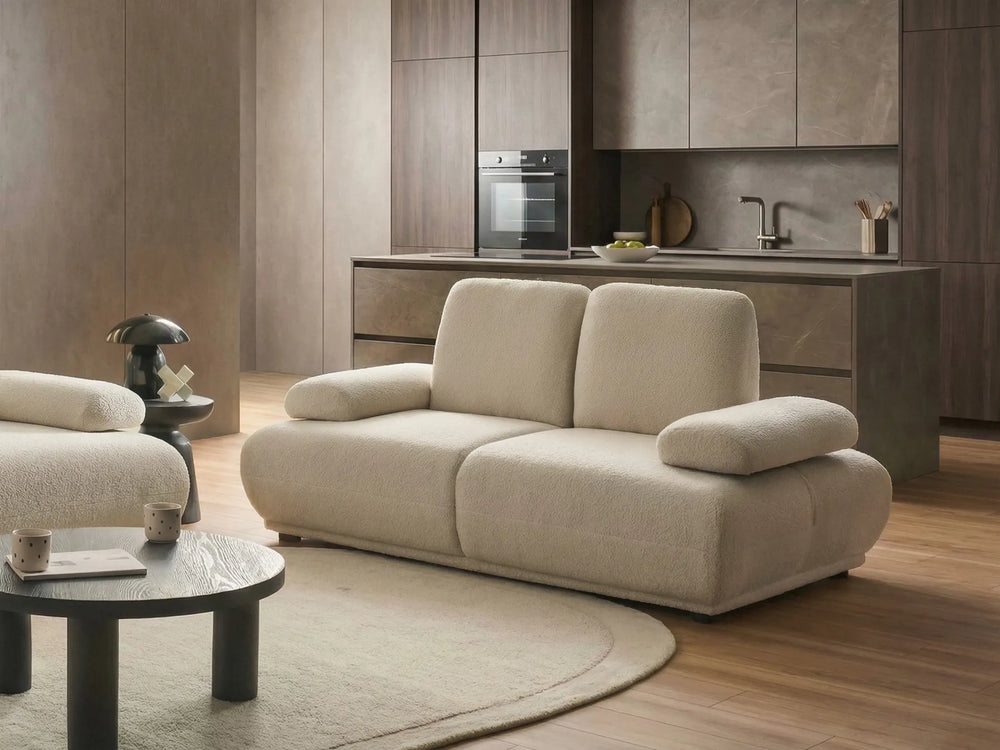 Beige sofa in a modern living room with kitchen in the background