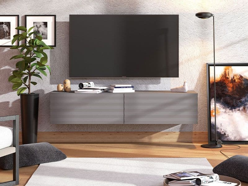 Modern living room with a gray TV stand, television, and decorative items.