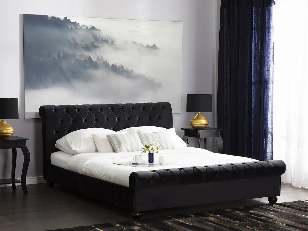 Modern bedroom with a black upholstered bed, white bedding, and decorative elements.