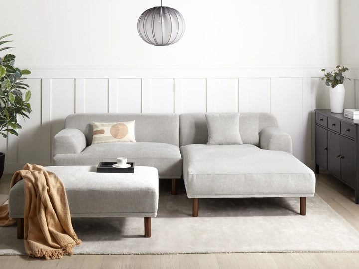 Gray sectional sofa in a modern living room with a coffee table and decorative items.