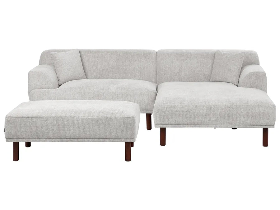 Gray sectional sofa with ottoman on a white background