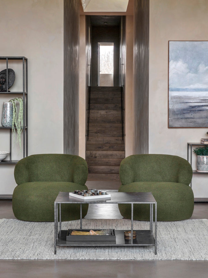Modern living room with green armchairs and a coffee table.