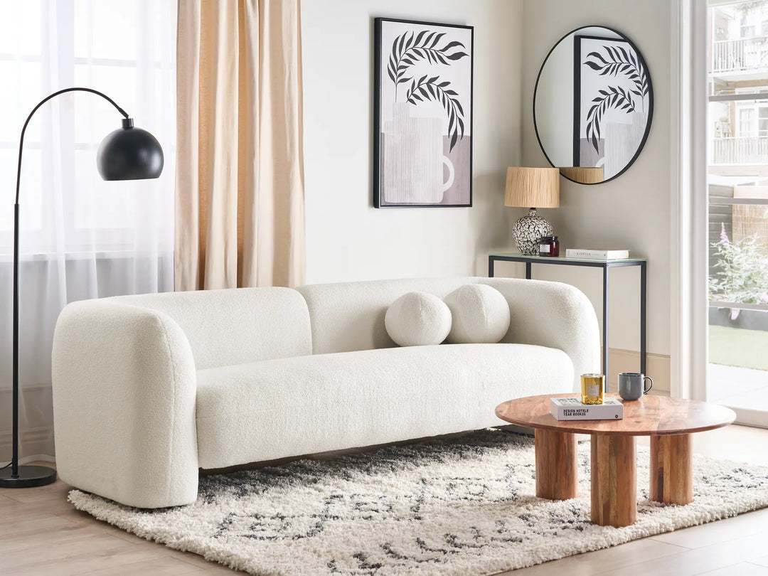 Modern living room with a white sofa, wooden coffee table, and decorative elements.