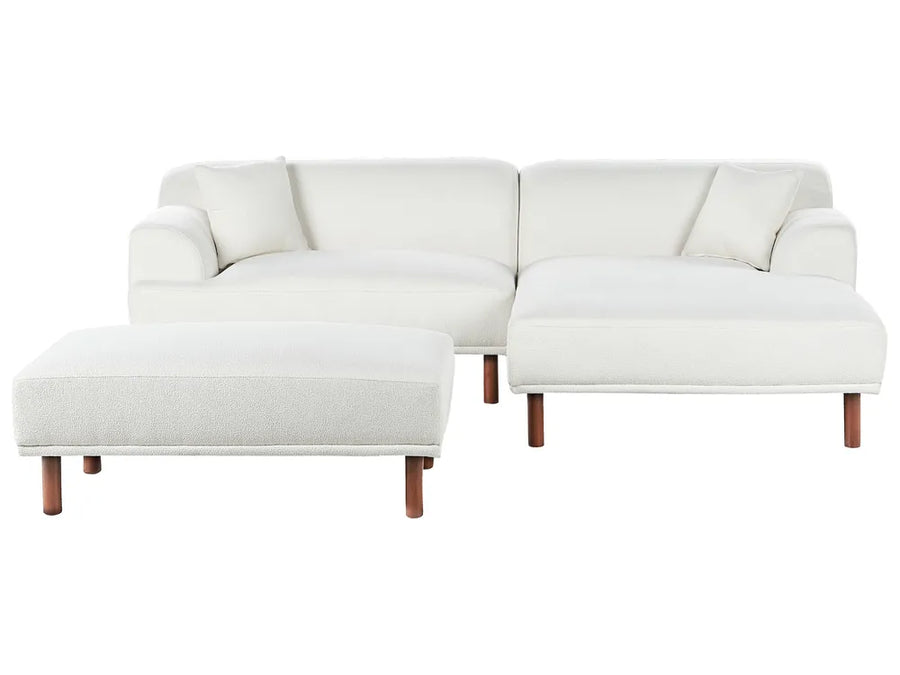 White sectional sofa with wooden legs on a white background
