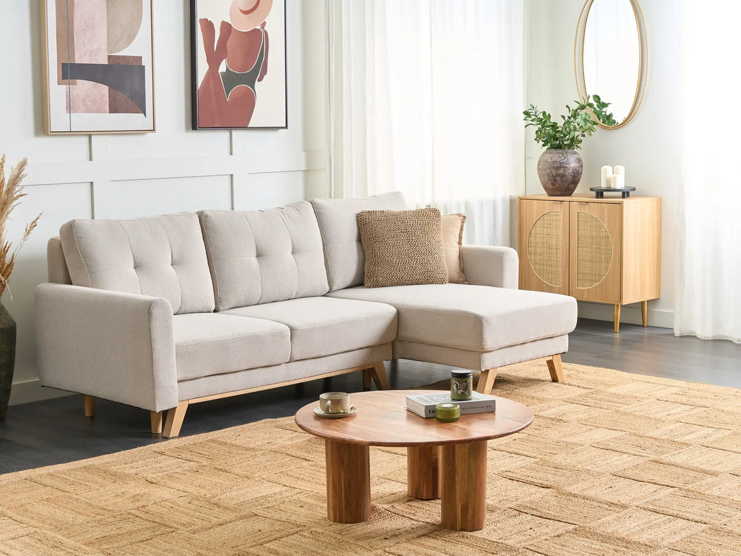 Modern living room with a beige sectional sofa, wooden coffee table, and decorative items.