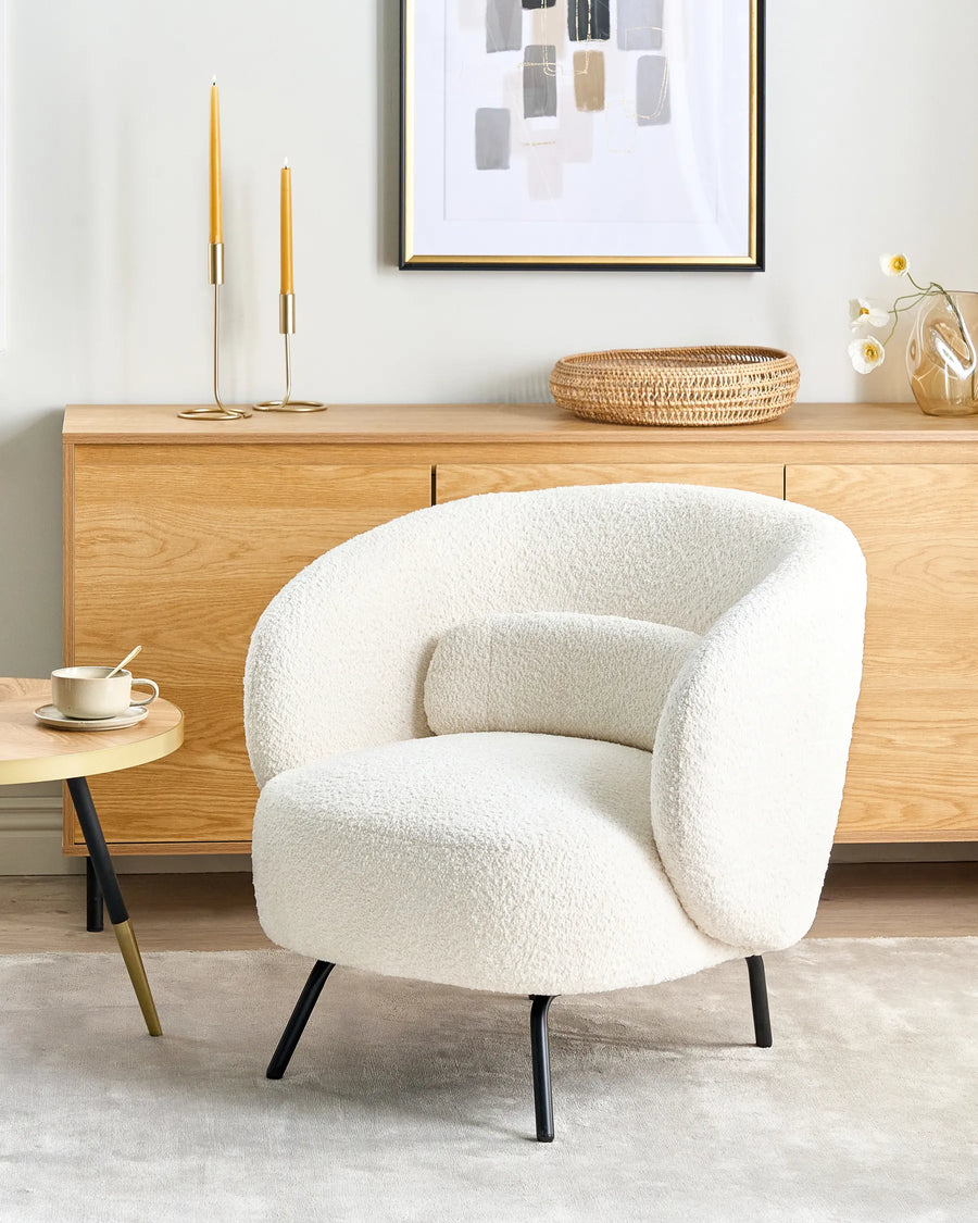 White textured armchair in a modern living room with wooden furniture and decor.