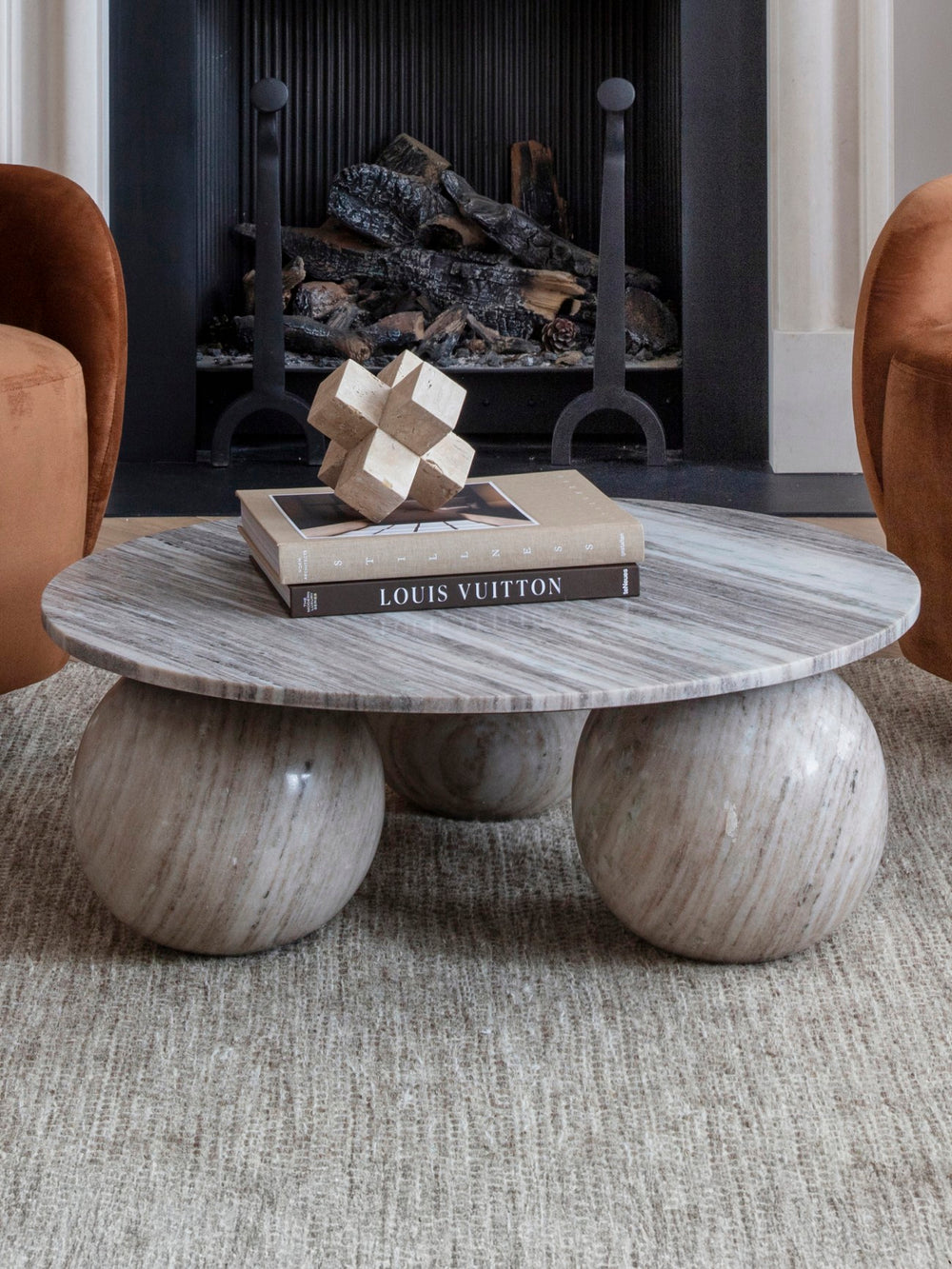 Coffee table with decorative items in a living room setting with a fireplace.