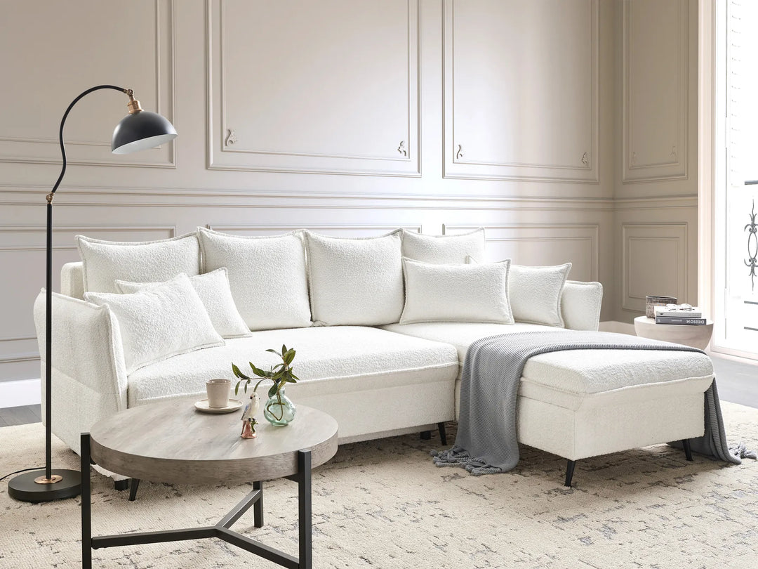 Modern living room with a white sectional sofa, coffee table, and decorative items.
