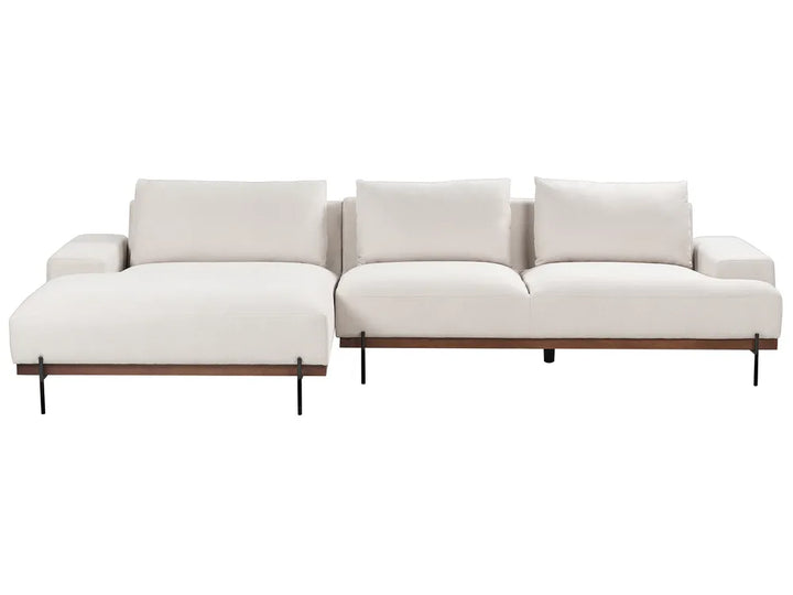 Light beige fabric right-hand corner sofa with low armrests and three cushions in a modern living room