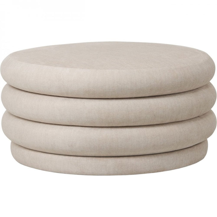 Beige ottoman with stacked cylindrical shapes on a white background