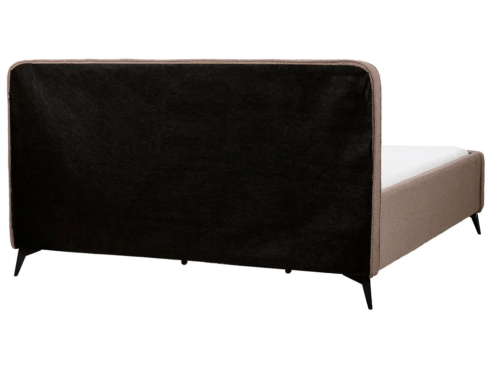 Bed with black upholstered headboard and beige frame on a white background