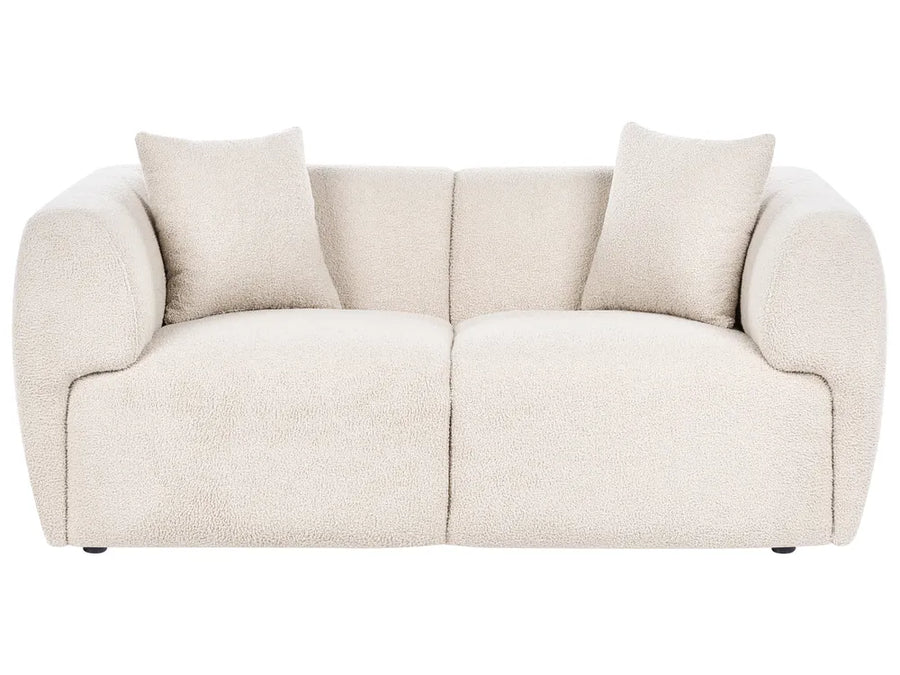 Beige sofa with three cushions on a white background
