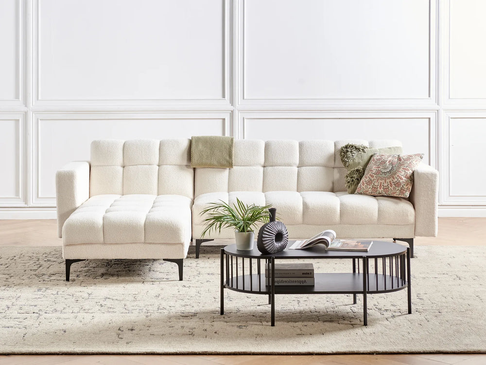 Beige sectional sofa with decorative pillows in a living room setting.
