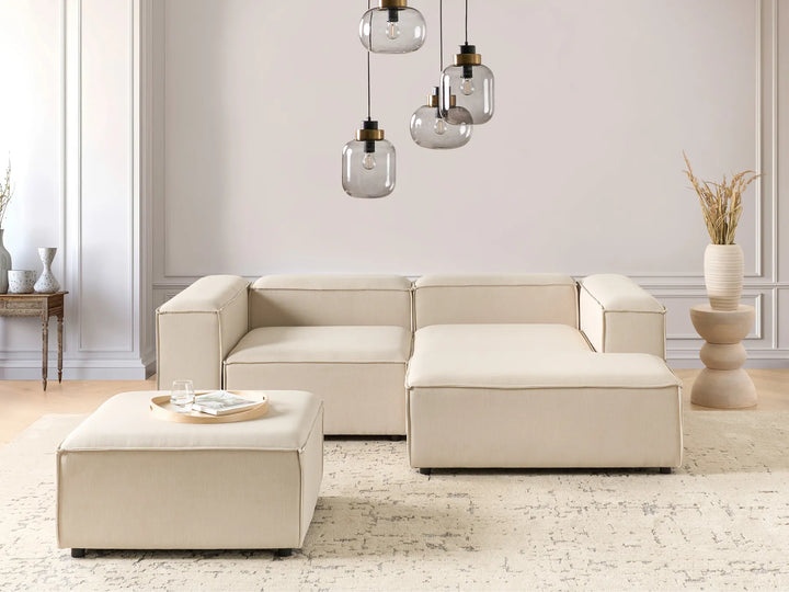 Beige fabric left-hand modular corner sofa with ottoman in a bright modern living room